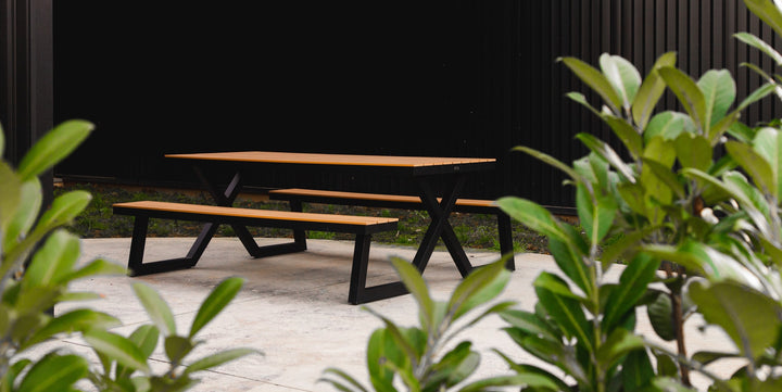 Koka piknika galds un soli parkā ar melnām metāla kājām